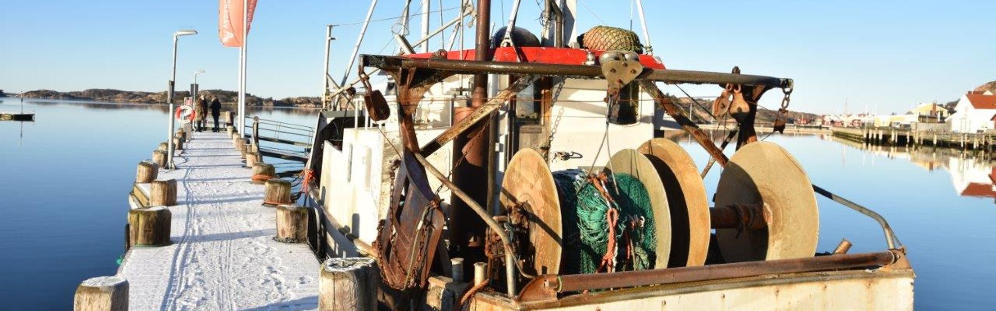 Fiskebåt vid en snöig brygga i Fjällbacka