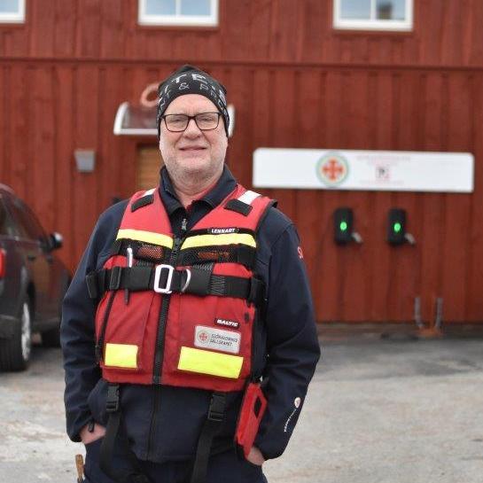 En sjöräddare står framför Sjöräddningshuset i Fjällbacka